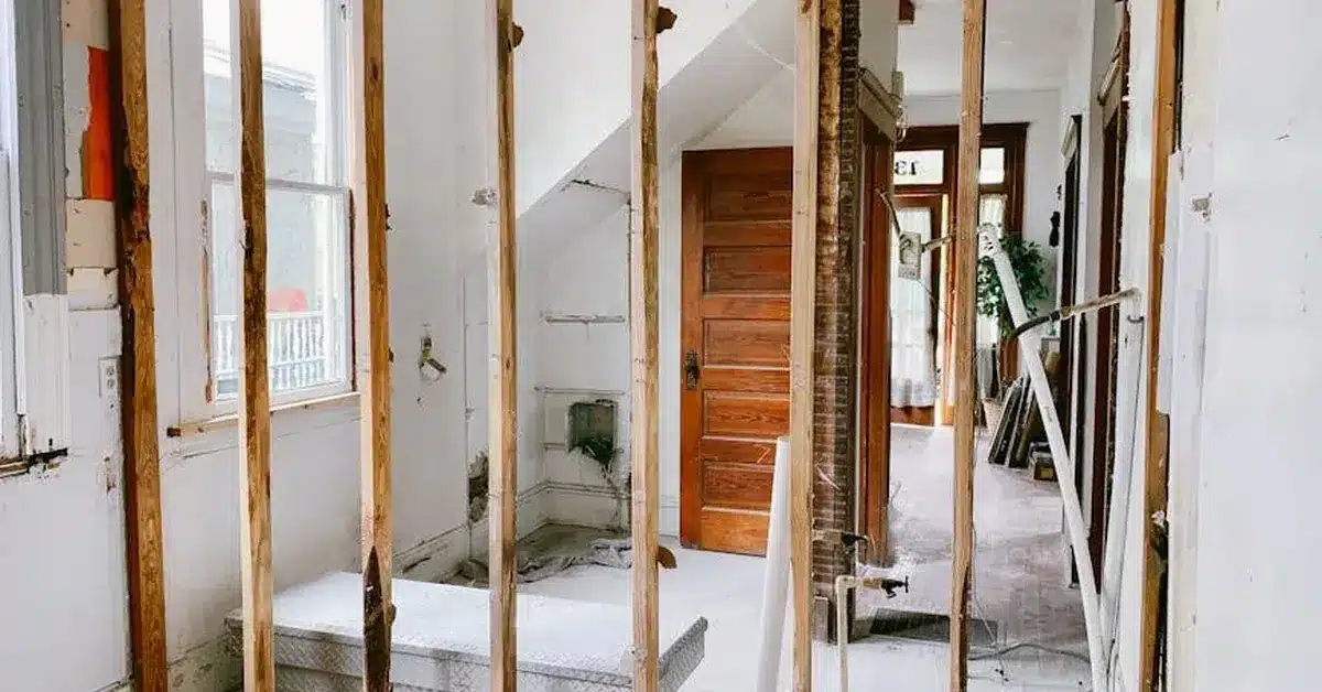 Exposed wooden studs and remaining drywall during interior demolition before finish work