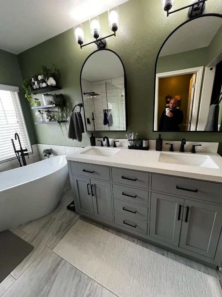 Double vanity bathroom with freestanding tub, matte black fixtures, and heated bathroom floors in a renovated home
