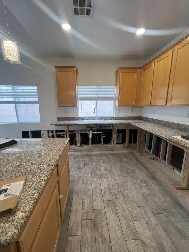 Kitchen remodel in progress with granite countertops and missing lower cabinets under installation.